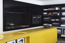 26 a moody black kitchen with a bold yellow kitchen island with lots of storage
