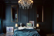 26 a moody luxurious bedroom with black panel walls, vintage mirrors and a chandelier and stunning parquet floors