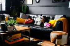 26 an eclectic space with black walls and furniture, a unique chandelier, framed artworks and clorful touches