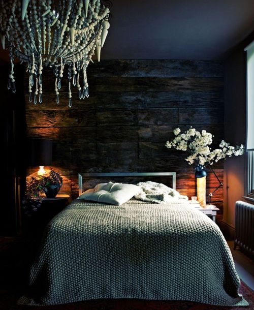 the base of this moody space is a very dark reclaimed wooden wall that sets the tone in the space