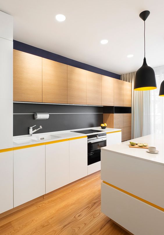 A modern kitchen with white and light colored wooden cabinets and some black touches for an eye catchy look