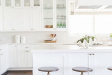 27 a simple white kitchen with glass cabinets and a large kitchen island leaves an airy feeling
