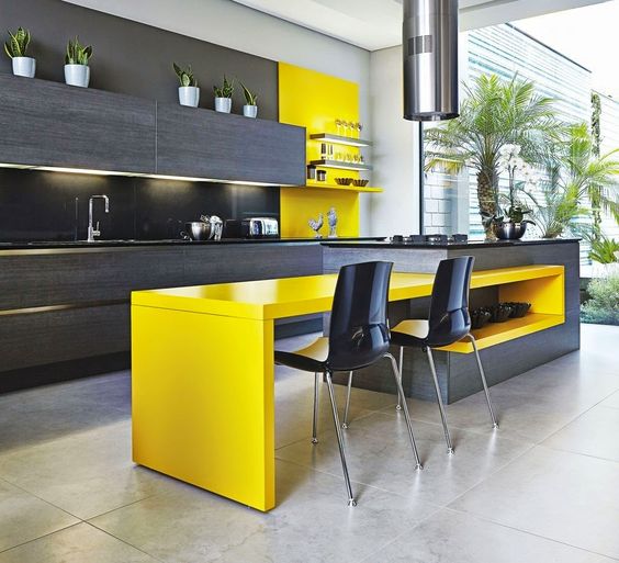 An ultra modern kitchen with dark grey cabinets and a yellow kitchen island for a dining space