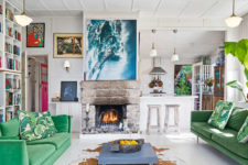 01 The living room has a strong wow effect, there’s a fireplace, emerald velvet sofas and a stunning artwork that depicts the ocean