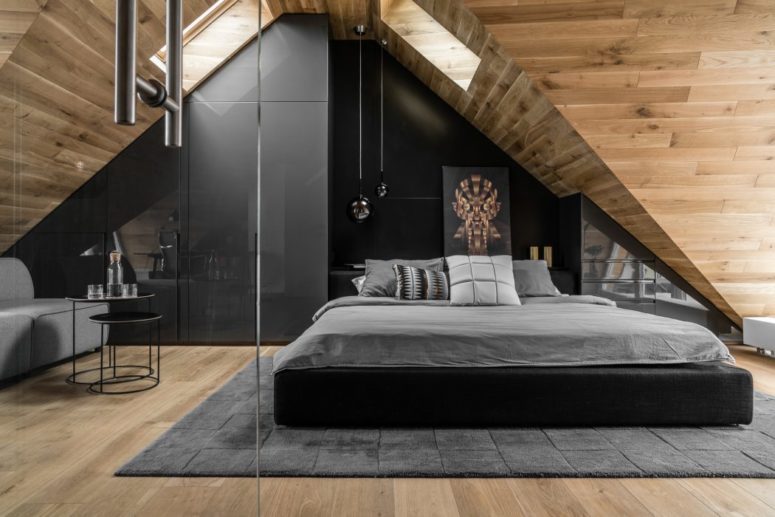 There's a black statement wall, an upholstered bed and an eye-catchy artwork, and skylights fill the space with light