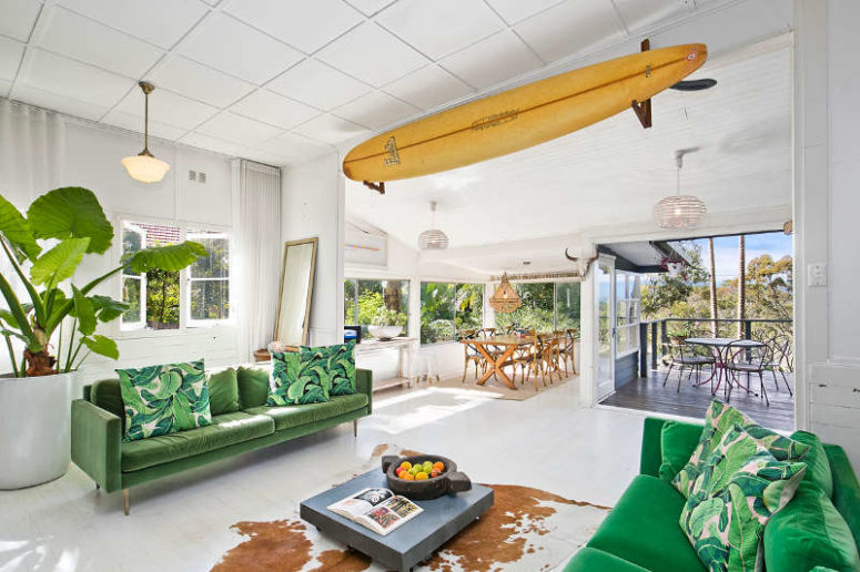 There's a surf over the entrance, and the room opens to a terrace and is connected to the dining space, there is potted greenery that refreshes the space