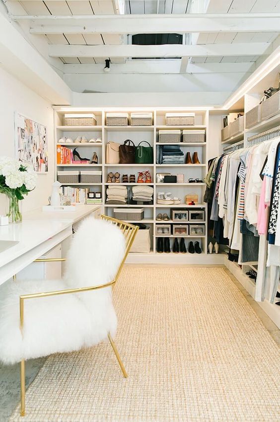 a girlish walk-in closet in glam style, with a gilded chair, faux fur and open shelving, there's also a makeup vanity