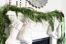 02 a lush evergreen garland, creamy stockings and striped candles make up a modern look with a rustic feel