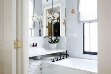 02 all-marble bathroom with a large mirror that takes almost the whole wall