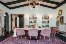 03 The dining space is done with black ceiling beams, dusty pink chairs and buil-in bookshelves that remind of castles