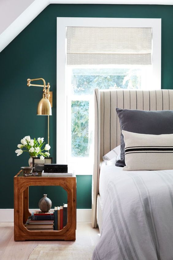 a gorgeous brass sconce with a vintage-inspired design looks amazing on an emerald wall