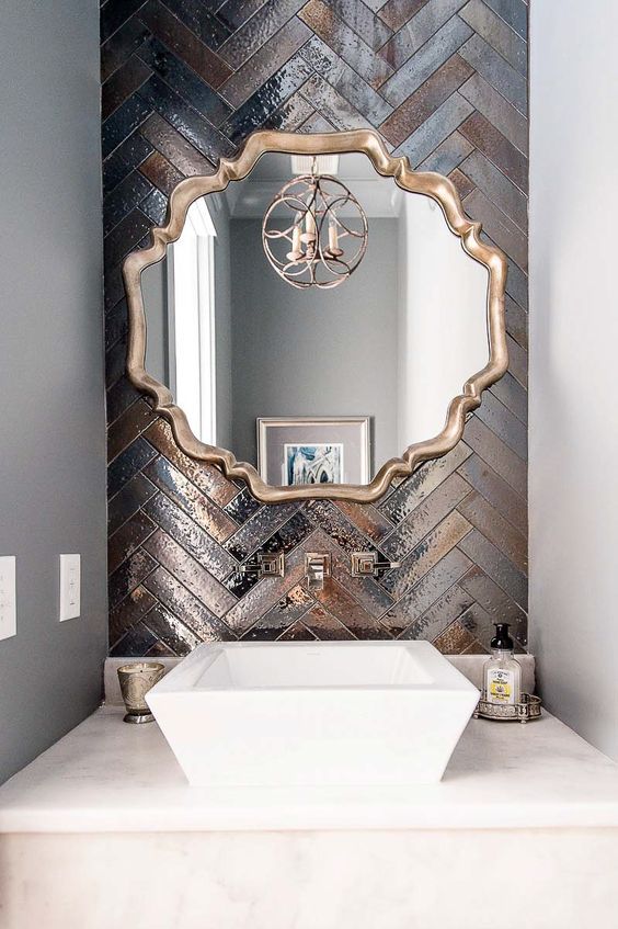 a gorgeous statement wall done with metallic tiles of different shades and clad in a herringbone pattern