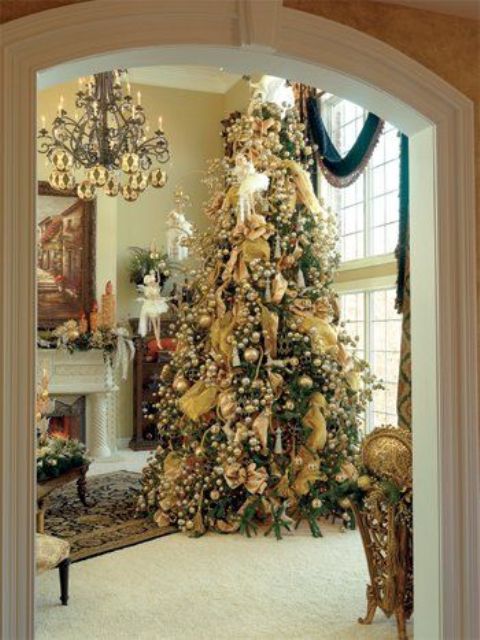 a large Christmas tree with lots of vintage ornaments in gold looks amazing