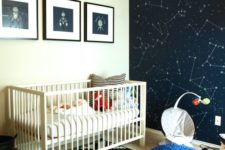 03 a space-themed nursery with a constellation statement wall, fun artworks and a navy pouf