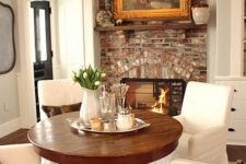 04 a cozy breakfast zone by the fireplace with a rich-colored wood pedestal table