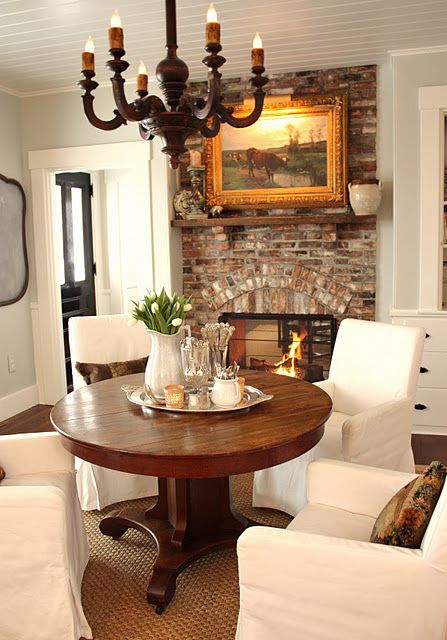 A cozy breakfast zone by the fireplace with a rich colored wood pedestal table