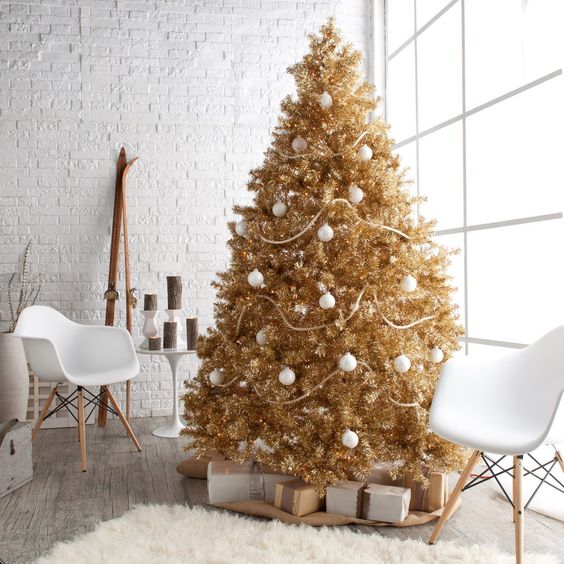 a gold Christmas tree decorated with white ornaments is great for a glam space