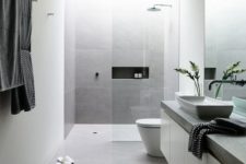 05 a minimal bathroom in white and grey, a glass shower and a stone countertop