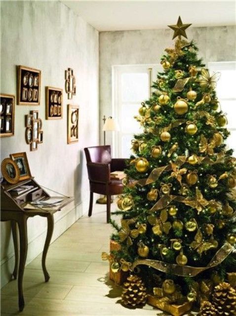 an emerald tree with gold ornaments looks chic and contrasting, this is a glam combo for the holidays