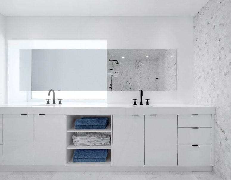The master bathroom is done in white and marble, there's a large double vanity with much storage