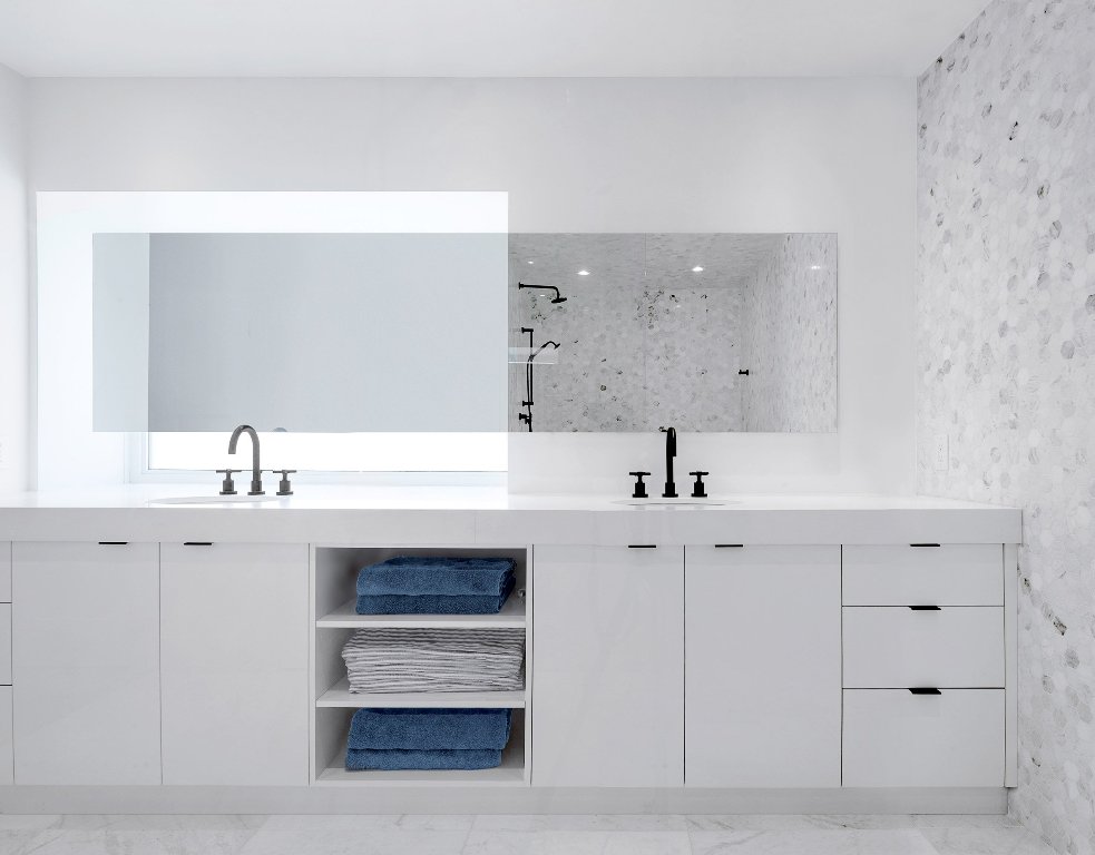 The master bathroom is done in white and marble, there's a large double vanity with much storage