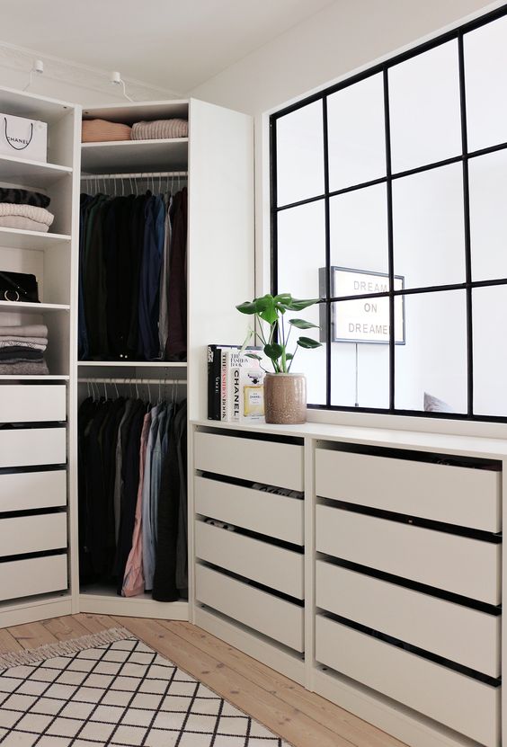a comfy modern walk-in closet with a large window and cabinets with drawers