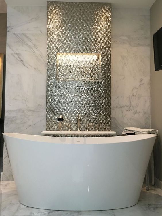 a marble statement wall and a shiny penny tile statement to highlight the bathtub
