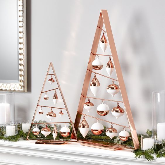 copper frame Christmas trees with white and copper ornaments, a fir garland and candles