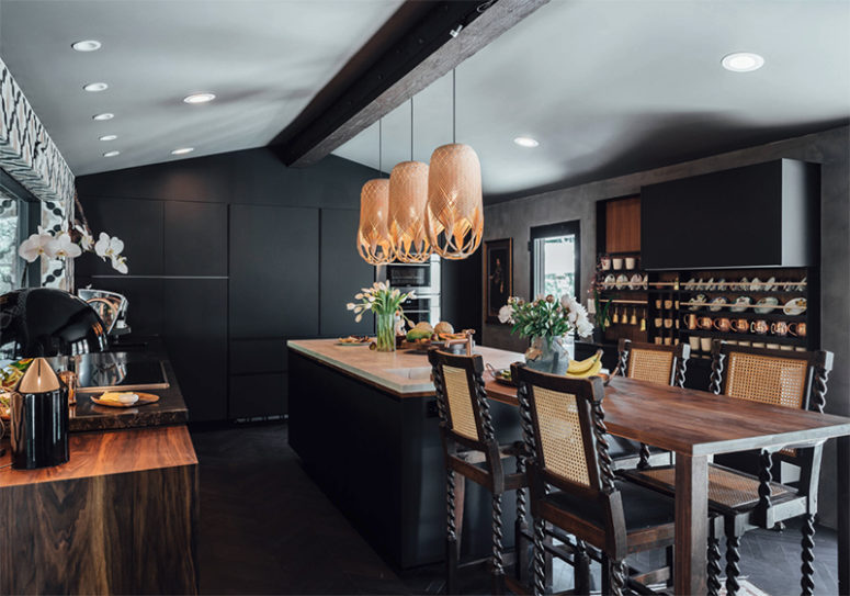Rich-colored wood touches, eye-catchy stools and pendant lamps over the kitchen island add eye-catchiness to the space