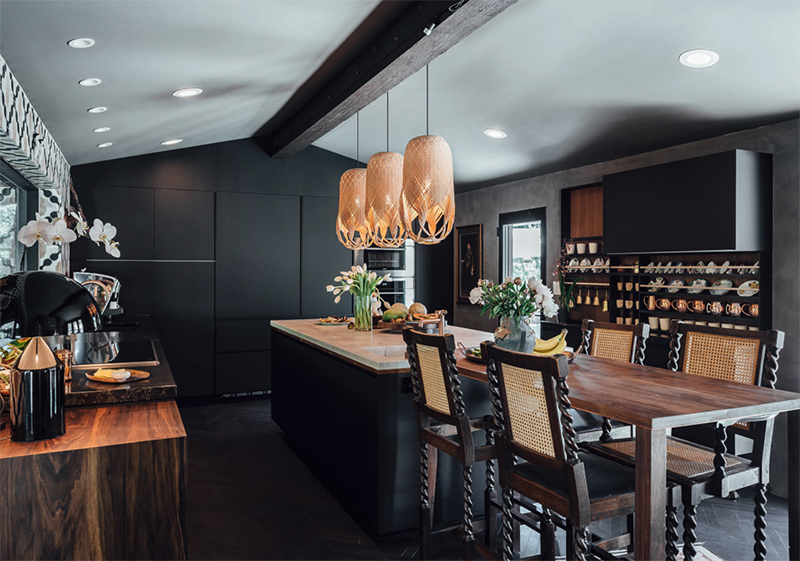 Rich colored wood touches, eye catchy stools and pendant lamps over the kitchen island add eye catchiness to the space