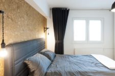 07 The bedroom features a cork wall, an upholstered bed, a black curtain