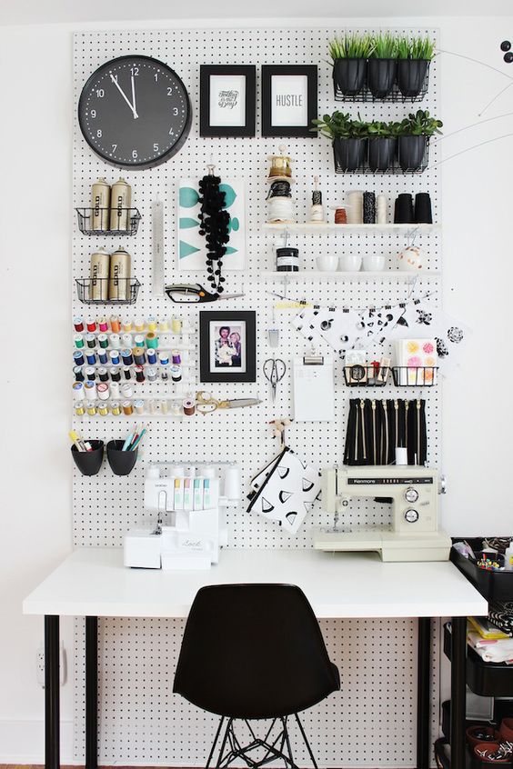 a comfy crafting nook with a large pegboard and a desk won't take much space