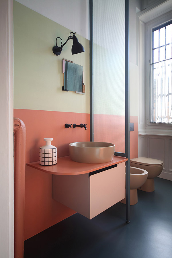 The master bathroom features a buttermlik and coral wall, a coral vanity and beige appliances
