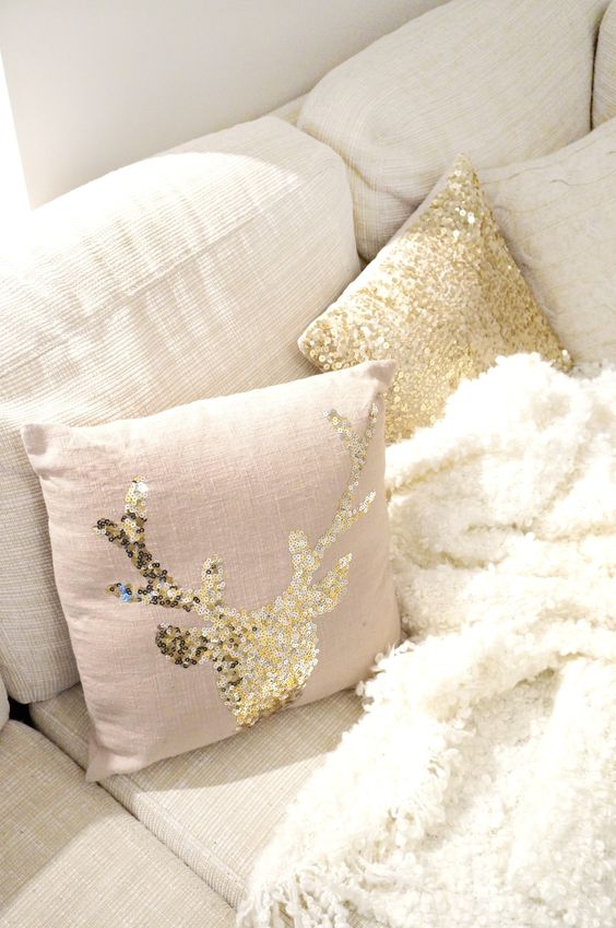 a blush pillow with a gold sequin deer is a cute idea for a woodland yet glam touch
