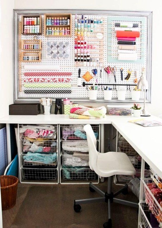 a cool sewing space with a corner desk and fabric storage drawers