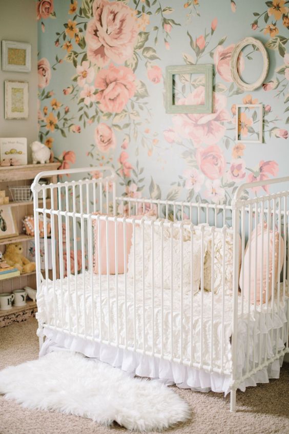 a sweet vintage-inspired girl's nursery with a floral statement wall