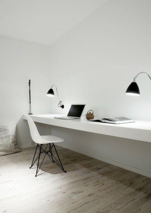 an ultra-minimalist home office with a floating double desk and black sconces