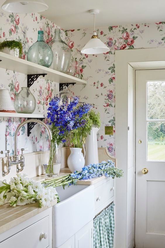 this chic light-filled ktichen is done with floral wallpaper, which makes the space cuter