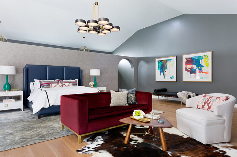 The master bedroom is done with colorful upholstered furniture, colorful artworks an creative rugs