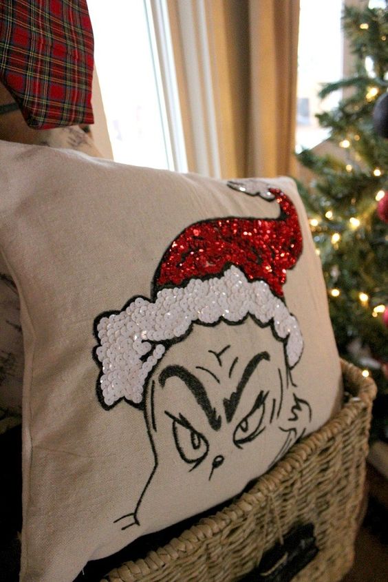 a fun Grinch pillow in red and white sequins looks super whimsy and bold and you can make it yourself