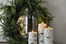 09 an evergreen wreath with birch branch candle holders for a rustic feel in your space
