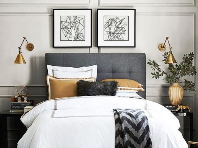 industrial brass sconces with an asymmetric shade add a cool touch to the bedroom