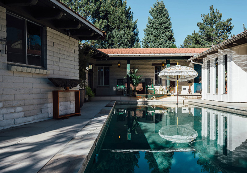 The backyard features a large swimming pool and a dining space