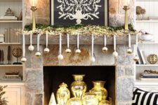 10 a glam fireplace and mantel display with shiny gold ornaments, a gold garland and gold vases inside