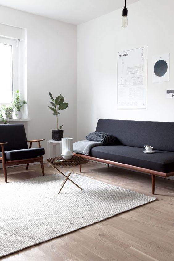 a minimalist interior with a Scandinavian feel, wood framed furniture and a jute rug