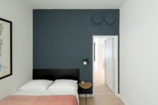 11 The second bedroom is done with a smoky blue statement wall, a large bed and an artwork