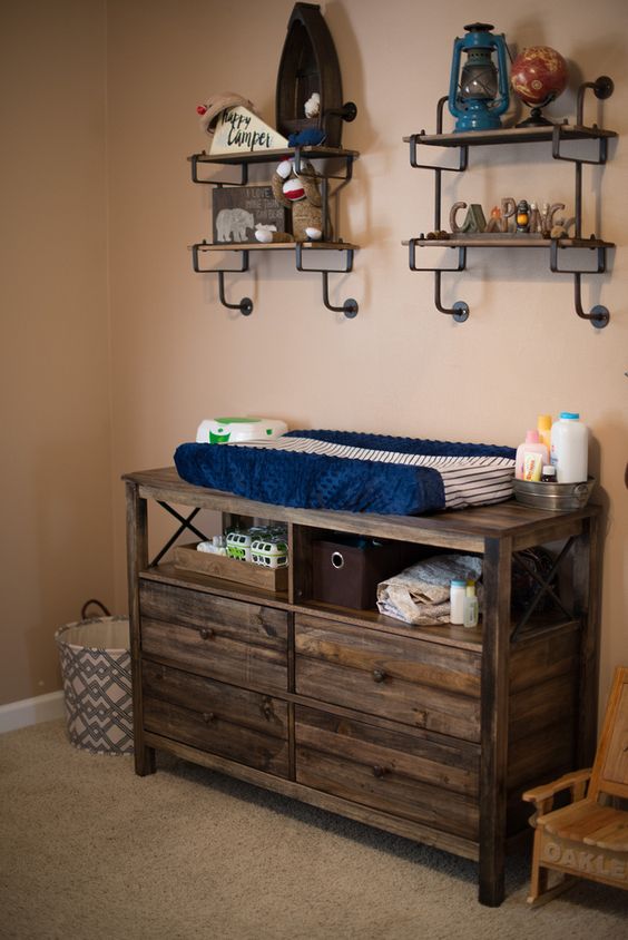 a dresser of reclaimed wood features open storage and can serve as a changing table