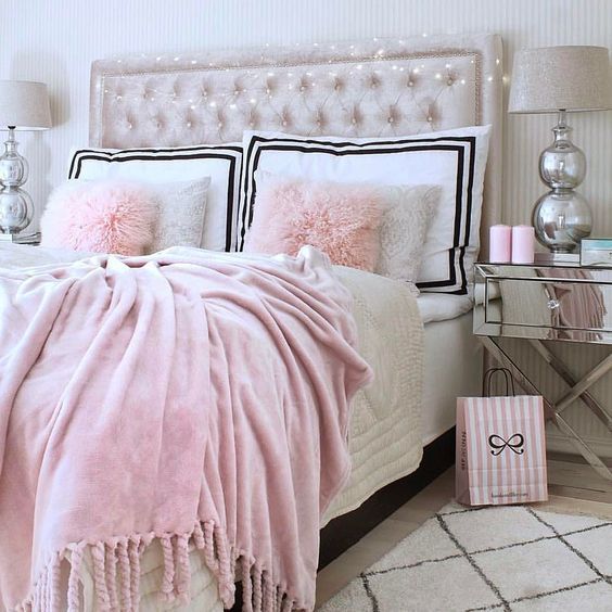 a pink velvet blanket, faux fur pillows and a creamy upholstered velvet headboard