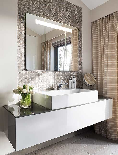 a shiny metal tile wall to highlight the sink and vanity and make them more glam