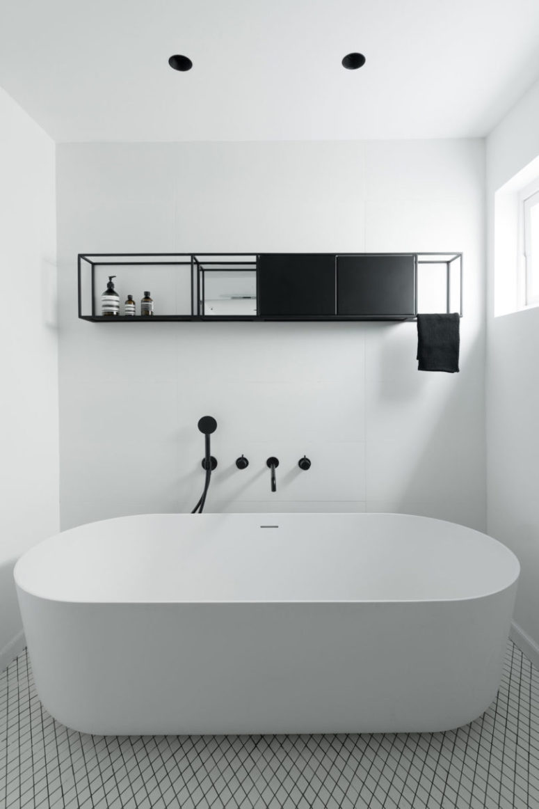 There's a bathroom with a large free-standing bathtub and a hanging shelf unit for storage